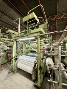 Maquinaria de una línea de producción textil en funcionamiento dentro de una planta industrial